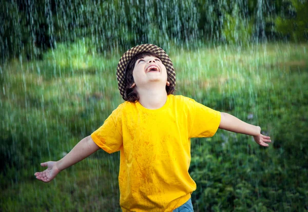 Šťastný chlapec v dešti letní venku — Stock fotografie