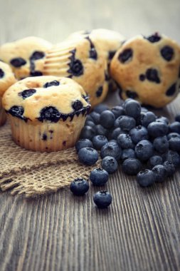 Muffin ahşap bir masa üzerinde yaban mersini ile. taze meyveleri ve swe
