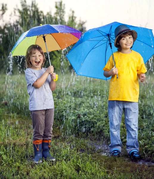 Açık havada şemsiye ile mutlu erkek kardeş — Stok fotoğraf