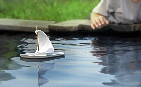 Barco de brinquedo branco em um cais em uma lagoa no verão — Fotografia de Stock