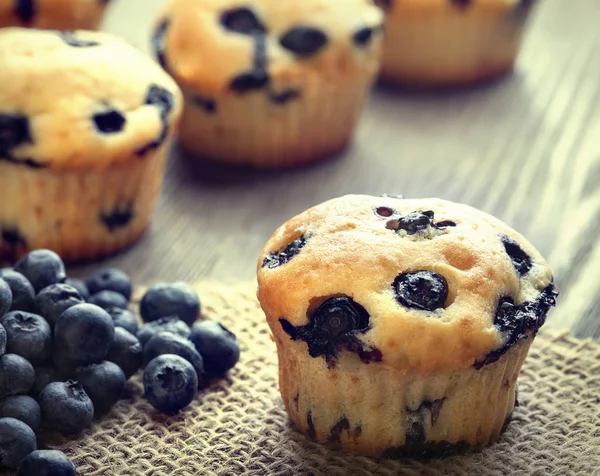 Muffins med blåbär på ett träbord. färska bär och swe — Stockfoto