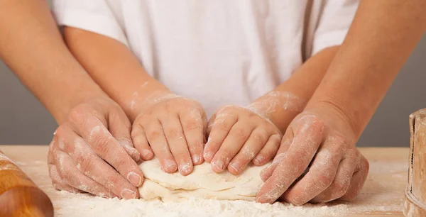 Dziecięce dłonie i ręce jego matka i ugniatać ciasta razem — Zdjęcie stockowe