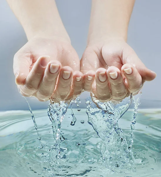 Vrouw handen in blauwe water — Stockfoto