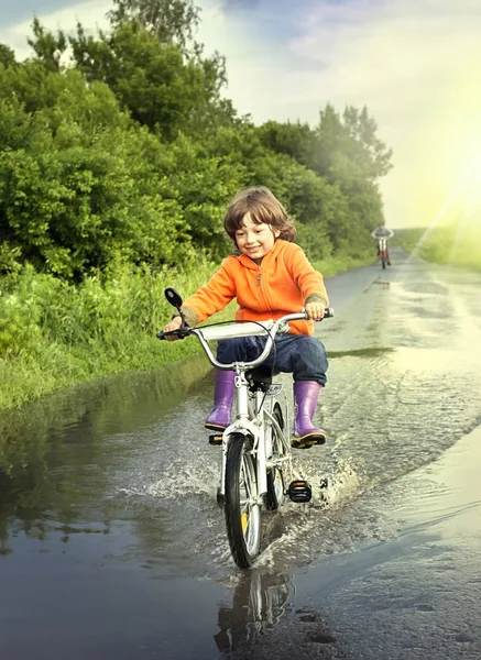 Niño feliz pasando por un charco — Foto de Stock