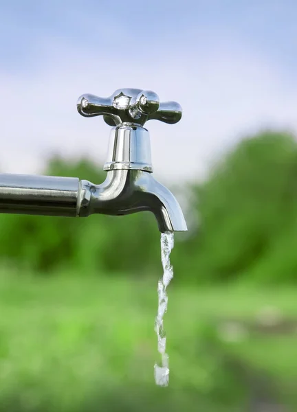 Drenar a água da torneira de metal ao ar livre — Fotografia de Stock
