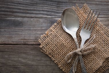 Eski çatal ve kaşık bir ahşap masa peçete ve çuval bezi, grunge r