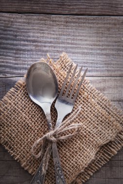 Eski çatal ve kaşık bir ahşap masa peçete ve çuval bezi, grunge r