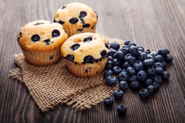 Muffin ahşap bir masa üzerinde yaban mersini ile. taze meyveleri ve swe