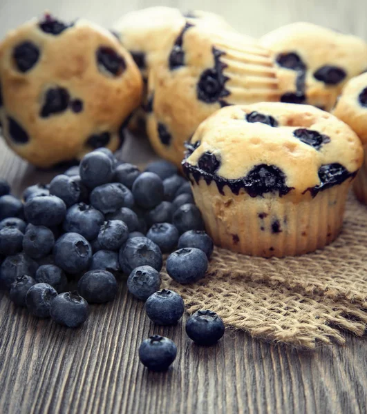 Muffins med blåbär på ett träbord. färska bär och swe — Stockfoto