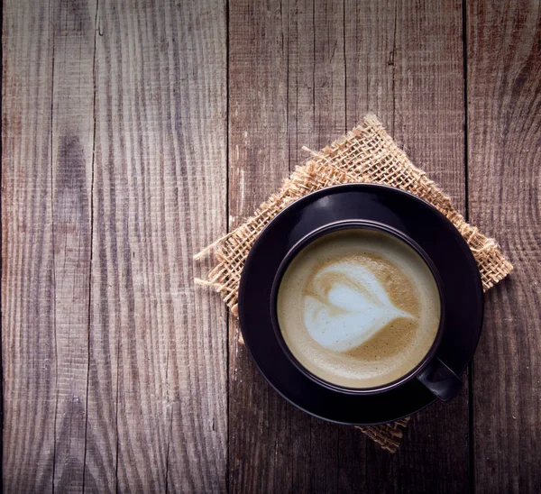 Šálek cappuccino káva na staré retro dřevěný stůl — Stock fotografie