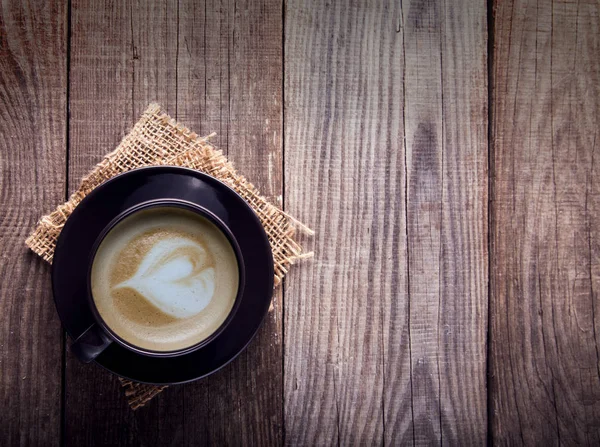 Šálek cappuccino káva na staré retro dřevěný stůl — Stock fotografie