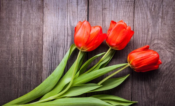 Tulipani rossi su vecchi grunge board in legno vista dall'alto — Foto Stock