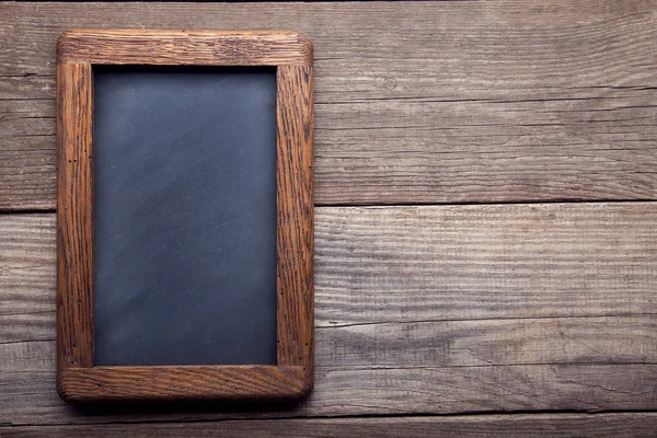 Oude school blackboard op een achtergrond van zwart houten panelen — Stockfoto