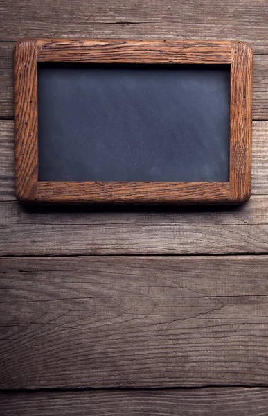 Quadro-negro velha escola em um fundo de painéis de madeira enegrecida — Fotografia de Stock