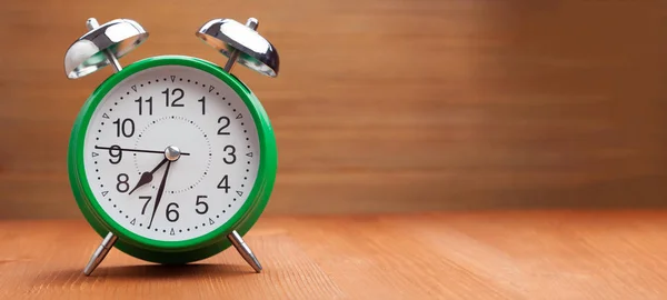 Clássico relógio de alarme verde manhã tempo de despertar no backgroun de madeira — Fotografia de Stock