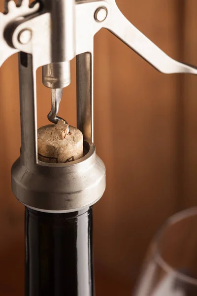 Corkscrew dan segelas anggur di atas meja kayu tua — Stok Foto