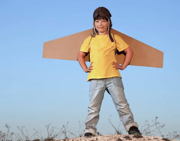 Ragazzo felice con scatole di cartone di ali contro cielo sogno di volare — Foto Stock