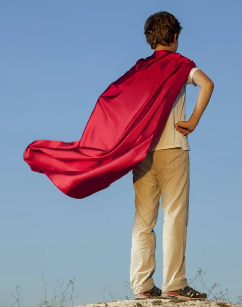 Junge spielt Superhelden am Himmel Hintergrund, Teenager-Superhelden — Stockfoto