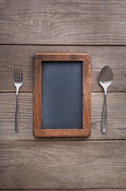 Tebeşir reco için kaba kare bir rustik masada kaşık ve çatal