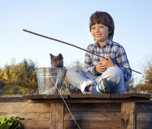 Gelukkige jongen gaan vissen op de rivier met huisdier, één kinderen en kit — Stockfoto