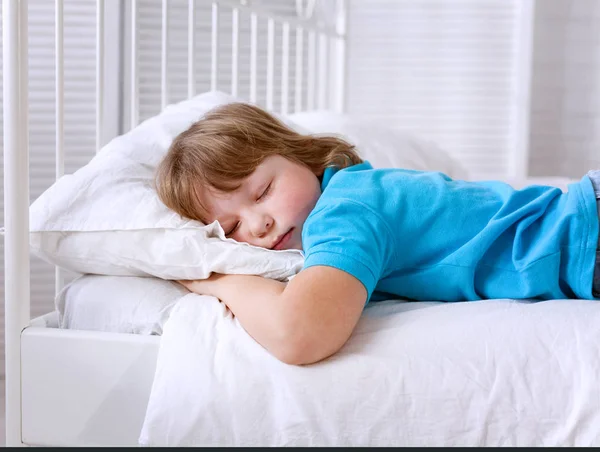 Bambino sta dormendo in camera a casa sul letto bianco — Foto Stock
