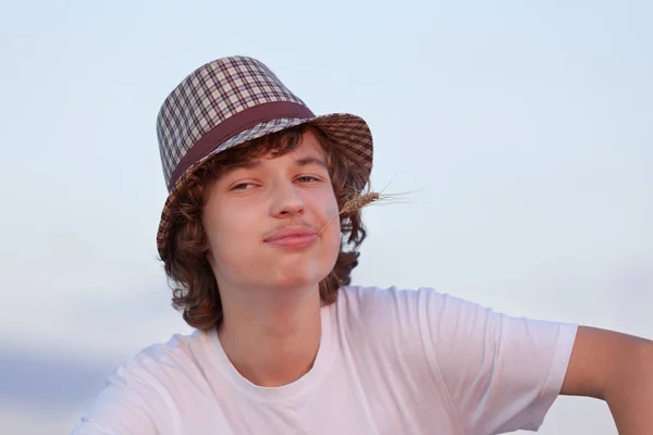 Gelukkig boy in de hoed op het gebied in de zomer — Stockfoto