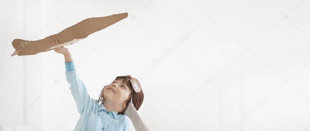 happy boy play with airplane in hand, child dreams about traveli