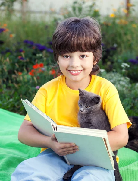 看书与小猫在院子里，孩子宠物读书的男孩 — 图库照片