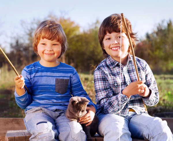 Gelukkige jongens gaan vissen op de rivier, twee kinderen van de fisherma — Stockfoto