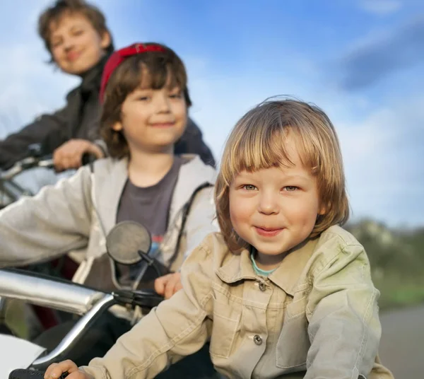 Three brothers ride bikes — Stock Photo, Image