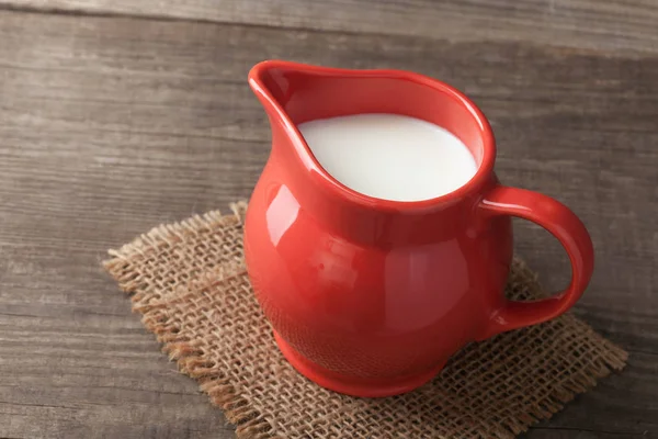 Milch im Glaskrug auf weißem Hintergrund Holztisch — Stockfoto