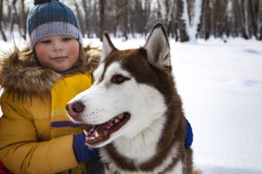 Çocuk kış günü dışarıda köpekle ya da köpekle oynuyor..