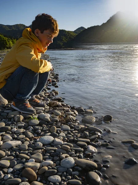 L'adolescent garçon sur la plage de la rivière de montagne — Photo