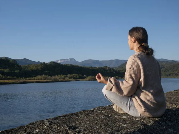 Frau übt Yoga in Lotus-Pose am Bergsee — Stockfoto