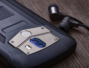 Kulaklık ve cep telefonu ahşap masada kulaklıklı akıllı telefon.