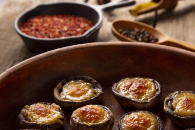 Erimiş peynirin altında maydanozlu sebzeli mantar.