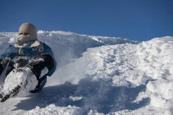 Glücklicher Junge, der im Winter auf dem Schlitten den Schneehügel hinuntergleitet, — Stockfoto