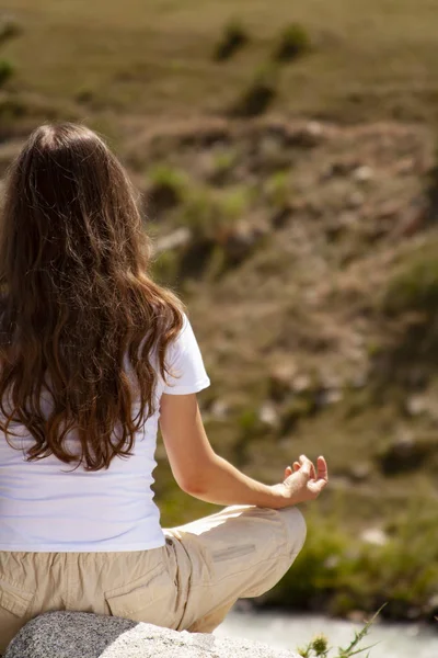 Junge Frau praktiziert Yoga in Lotus-Pose am Berg — Stockfoto