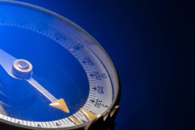 Mavi arka planda klasik manyetik pusula. Makro fotoğraf