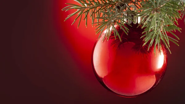 Χριστουγεννιάτικη κόκκινη μπάλα διακοσμήσεις με έλατο στο κόκκινο φόντο — Φωτογραφία Αρχείου