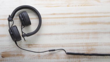 Ahşap arka planda uzun kablolu modern kulaklıklar, Müzik onli