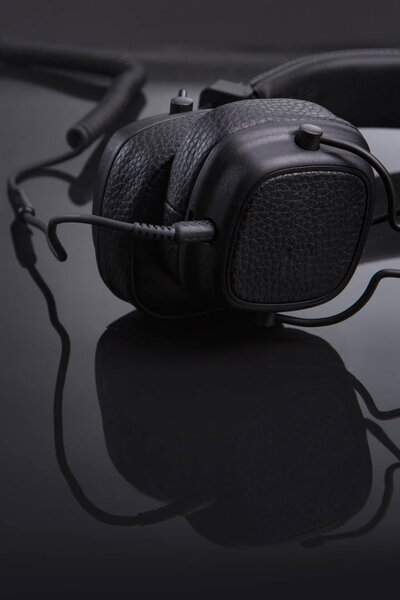Black headphones on a glossy table close-up