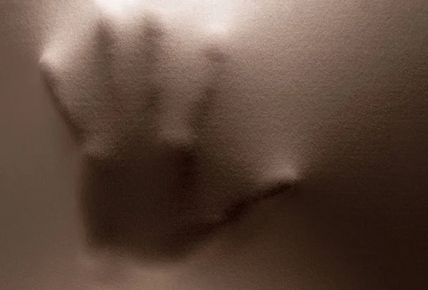 Menschliche Hand, die als Horror-Hintergrund durch Stoff drückt — Stockfoto