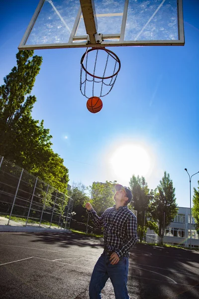 Мальчики играют в баскетбол на открытом воздухе на спортивной площадке — стоковое фото