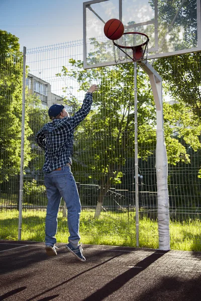 Мальчики играют в баскетбол на открытом воздухе на спортивной площадке — стоковое фото