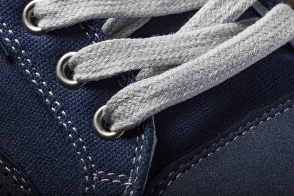 Fragment of a blue sneaker with white drawstring macro. — Stock Photo, Image