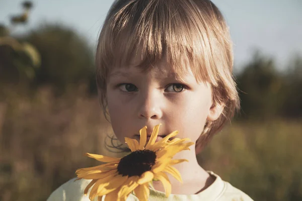 Dışarıda ayçiçekli bir çocuk — Stok fotoğraf