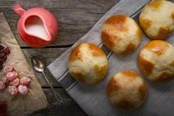 Petits pains chauds sur table en bois servis avec du lait et des fruits secs , — Photo