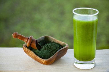 Yeşil çimen arka planında spirulinalı yeşil smoothie