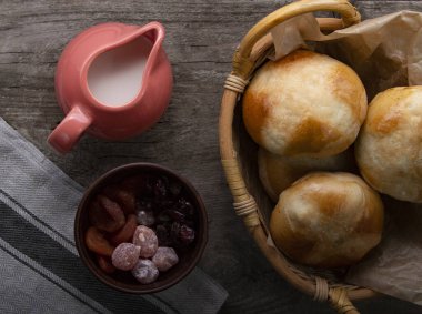 Sıcak haç çörekleri, süt, kurutulmuş meyve, bıçak ve bir sürahi kremayla servis edilir. Üst görünüm, boşluğu kopyala. Paskalya pastası.